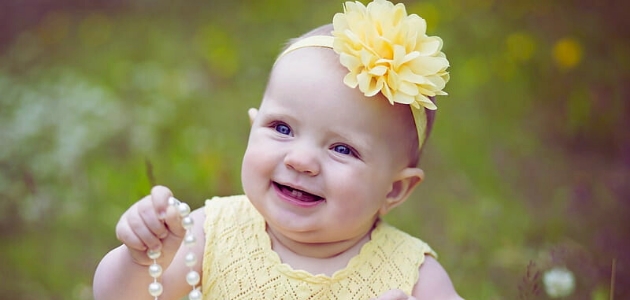 اسم مريم في اللغة العربية؛ طفلة صغيرة ترتدي ملابس صفراء وتضع ربطة صفراء على شعرها في حديقة خضراء 