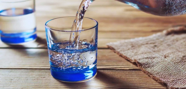 الماء وفوائده؛ كأسين زجاجين أحدهما يحوي ماء والآخر يصب فيه إبريق ماء.