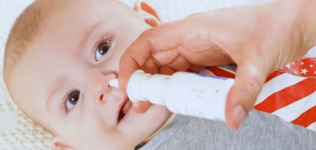 علاج الاحتقان عند الأطفال؛ طفل رضيع يُعالج بواسطة بخاخ أنف.